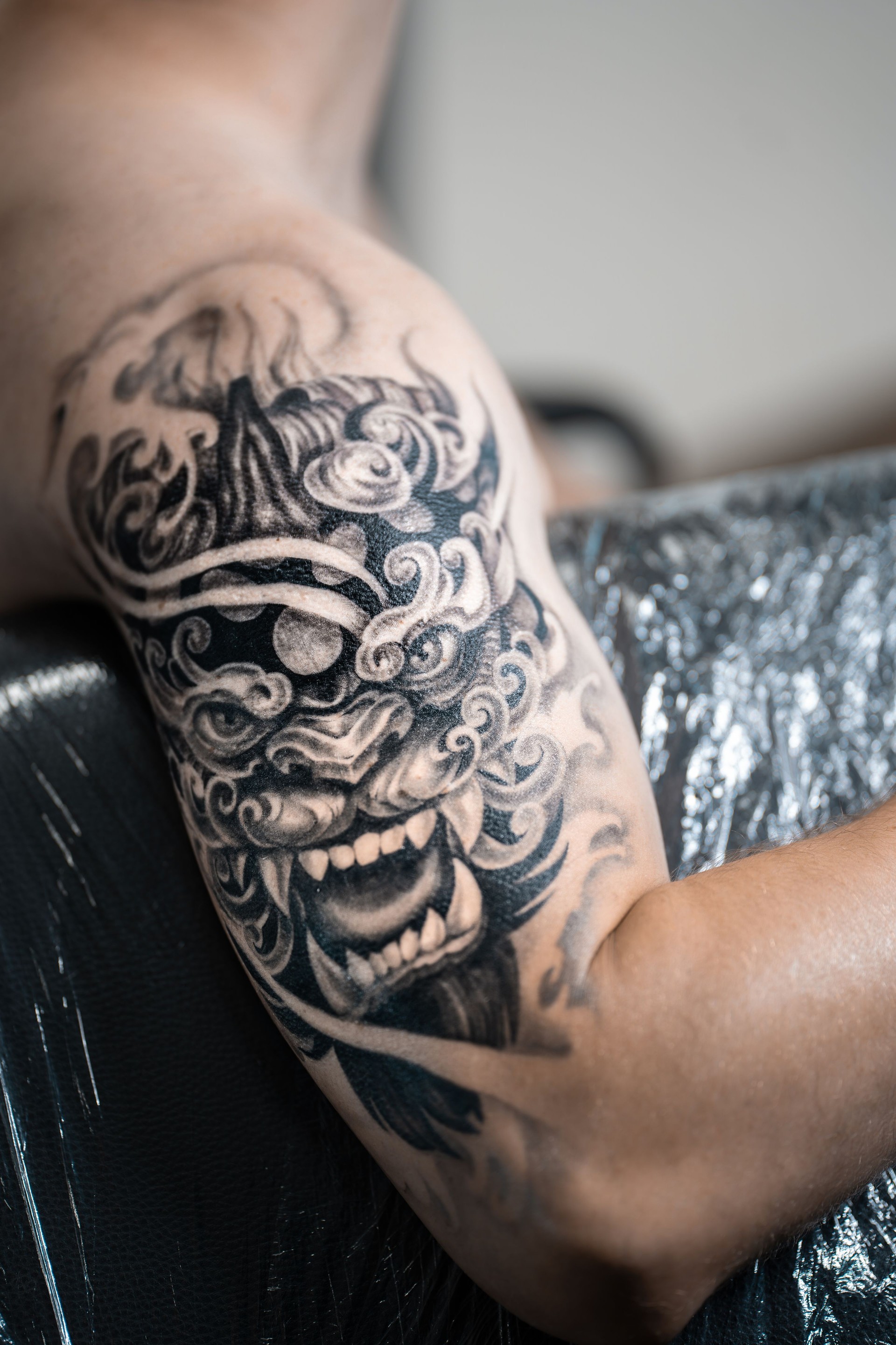 stylish black tattoo of Japanese demon mask on man hand, body art
